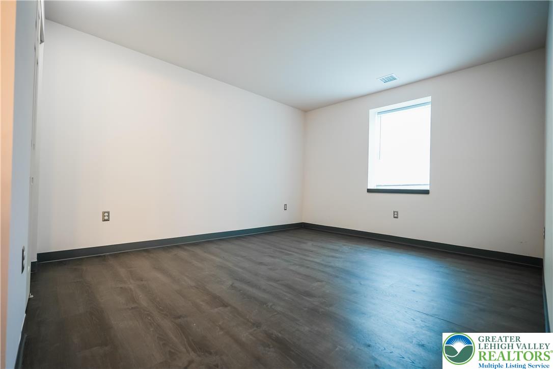 335 Walnut Drive, Unit 1 Northampton, PA 18067 - Photo 13 of 29 an empty room with wooden floor and windows