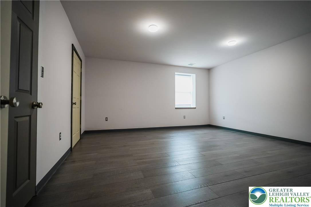 335 Walnut Drive, Unit 1 Northampton, PA 18067 - Photo 8 of 29 an empty room with wooden floor and windows