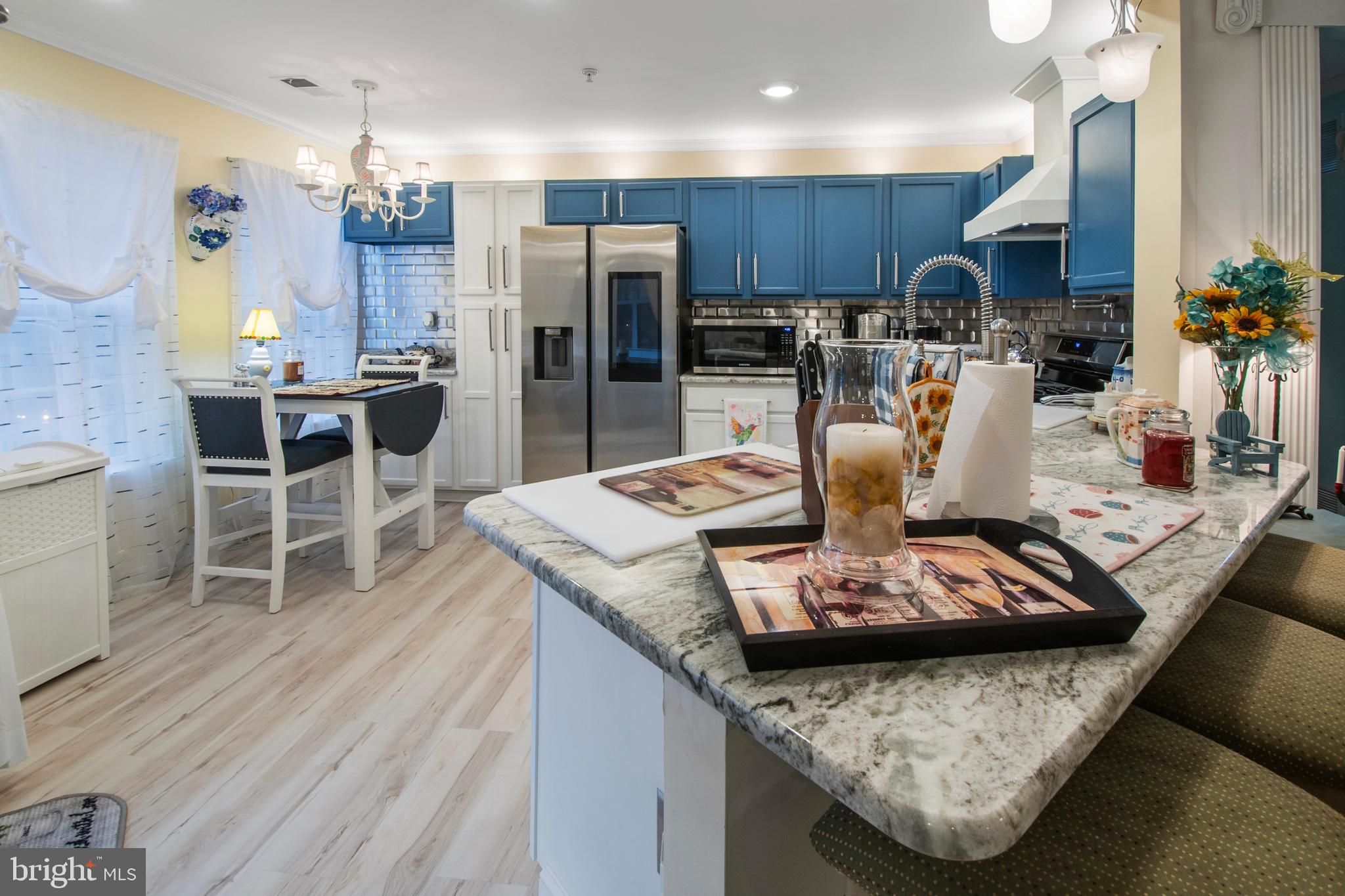 511 Mowat Circle Hamilton, NJ 08690 - Photo 11 of 46 a kitchen with stainless steel appliances wooden floor dining table and chairs