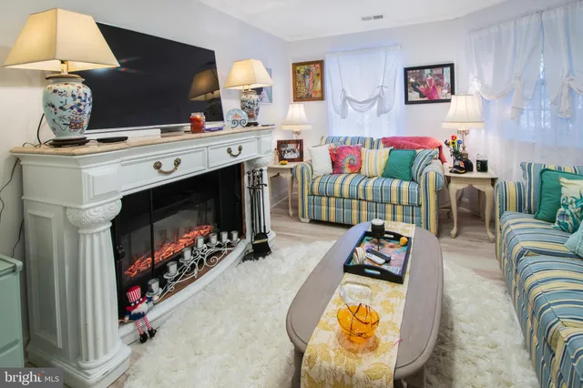 a living room with furniture a flat screen tv and a fireplace