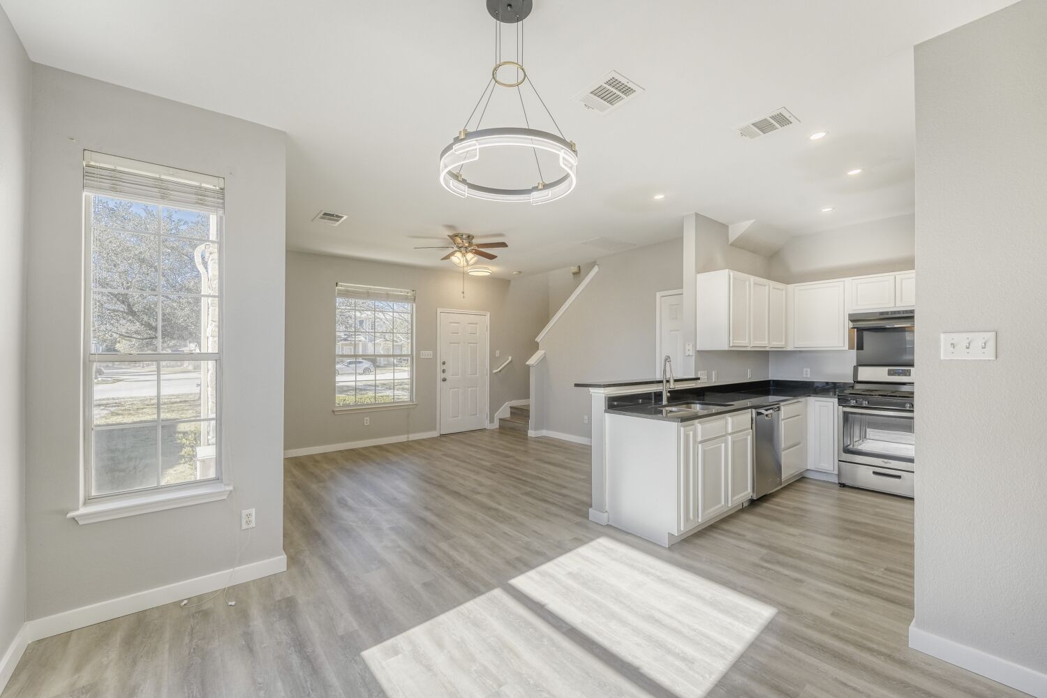 a large kitchen with granite countertop a stove and wooden floor