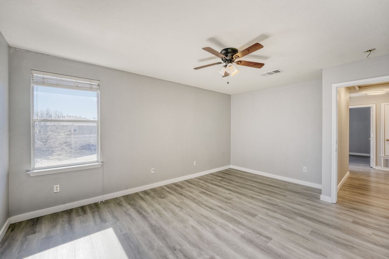 904 Sebastian Bend, Unit B Pflugerville, TX 78660 - Photo 20 of 30 a view of a room with wooden floor and a ceiling fan