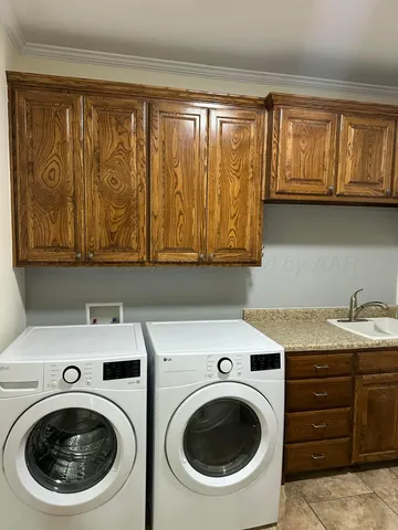 a bathroom with a granite countertop sink and washing machine