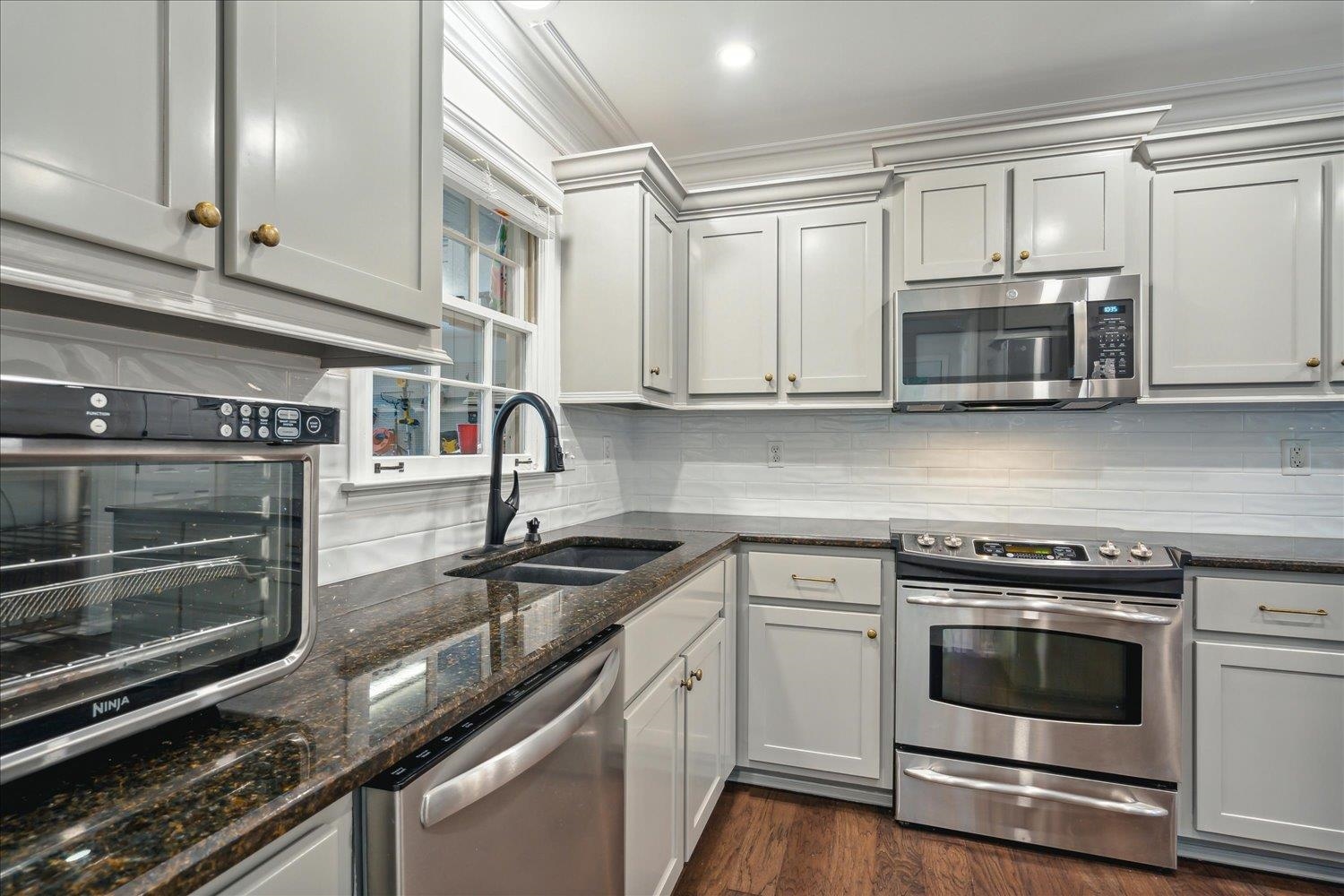 1001 Yorktown Road Collierville, TN 38017 - Photo 14 of 40 Kitchen with dark hardwood / wood-style floors, backsplash, appliances with stainless steel finishes