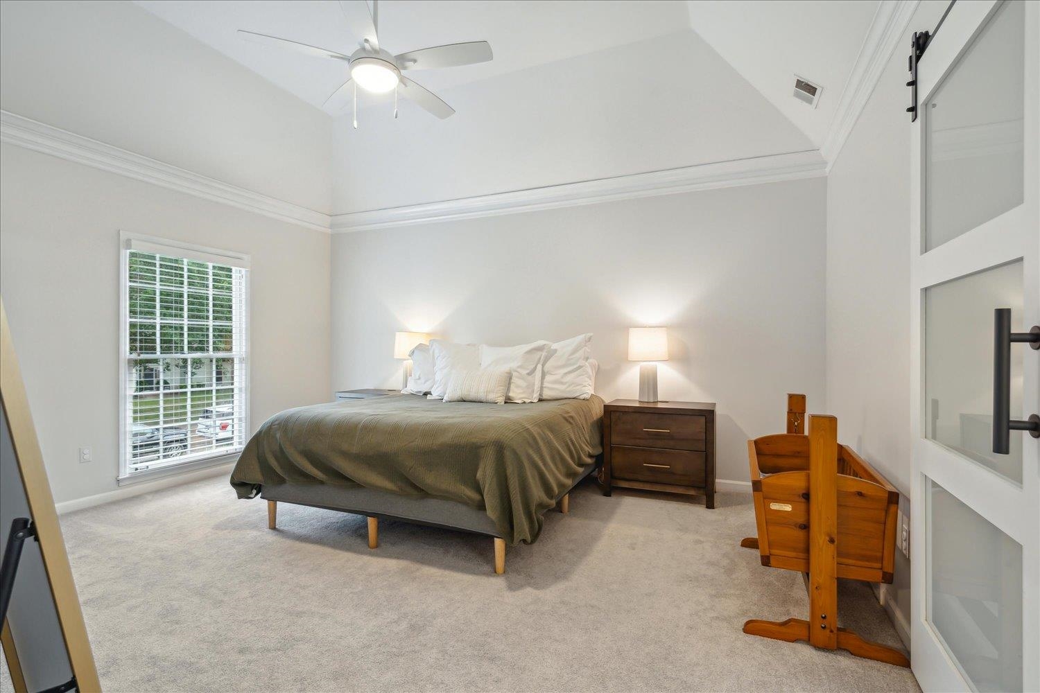 1001 Yorktown Road Collierville, TN 38017 - Photo 19 of 40 Carpeted bedroom with crown molding, high vaulted ceiling, a barn door, and ceiling fan