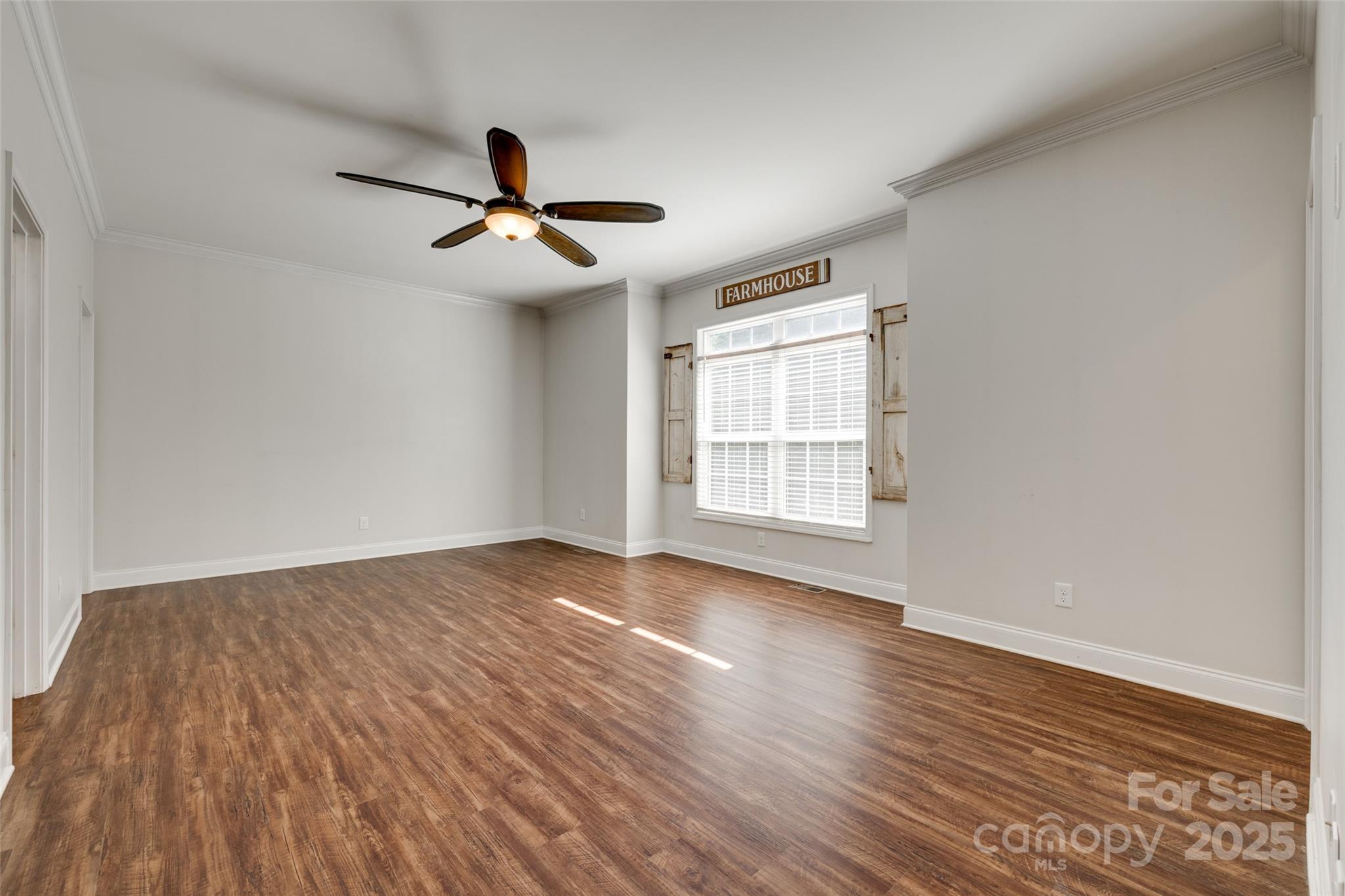 3243 Farmcrest Court Fort Mill, SC 29708 - Photo 11 of 45 an empty room with wooden floor ceiling fan and windows