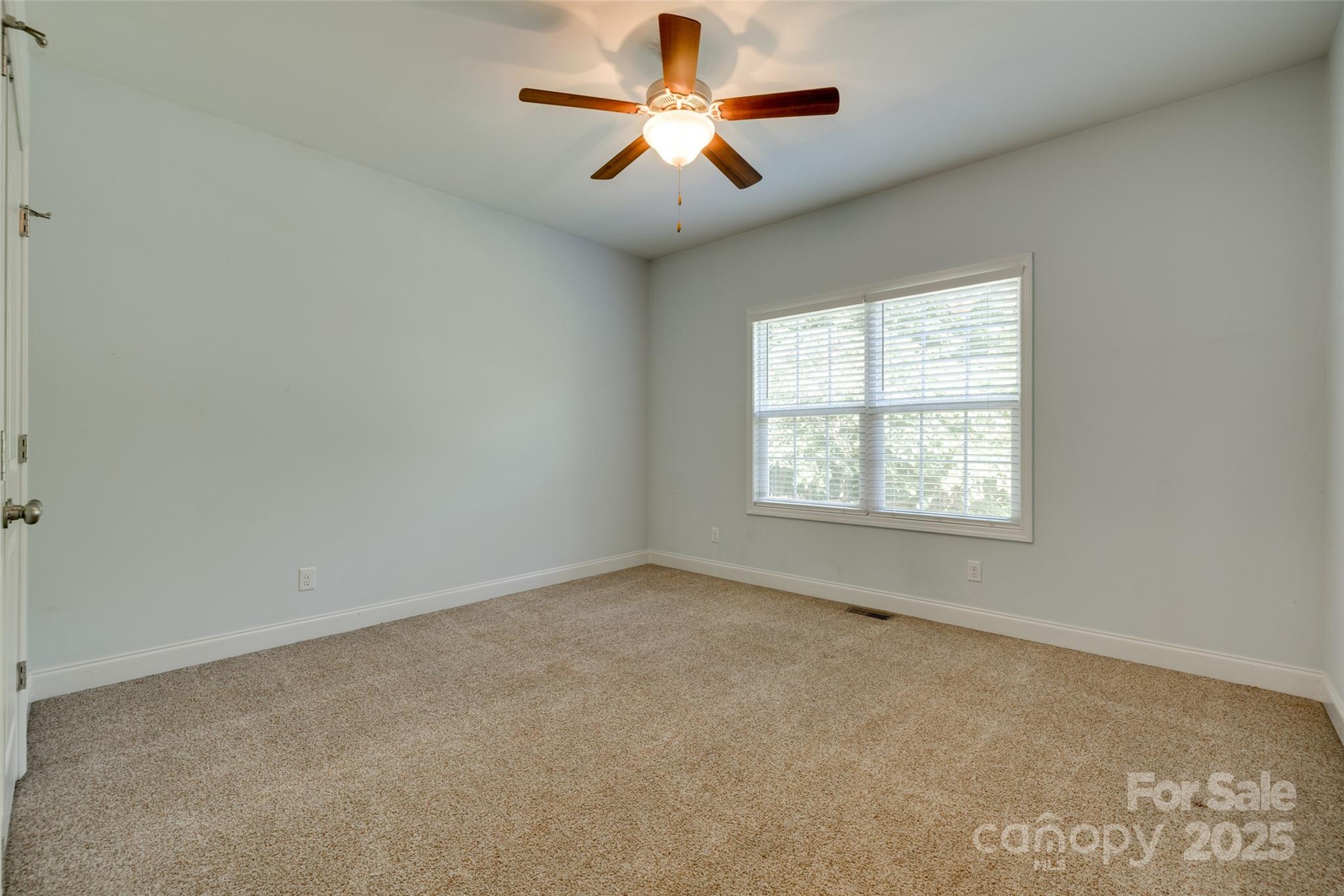 3243 Farmcrest Court Fort Mill, SC 29708 - Photo 19 of 45 an empty room with windows and chandelier fan