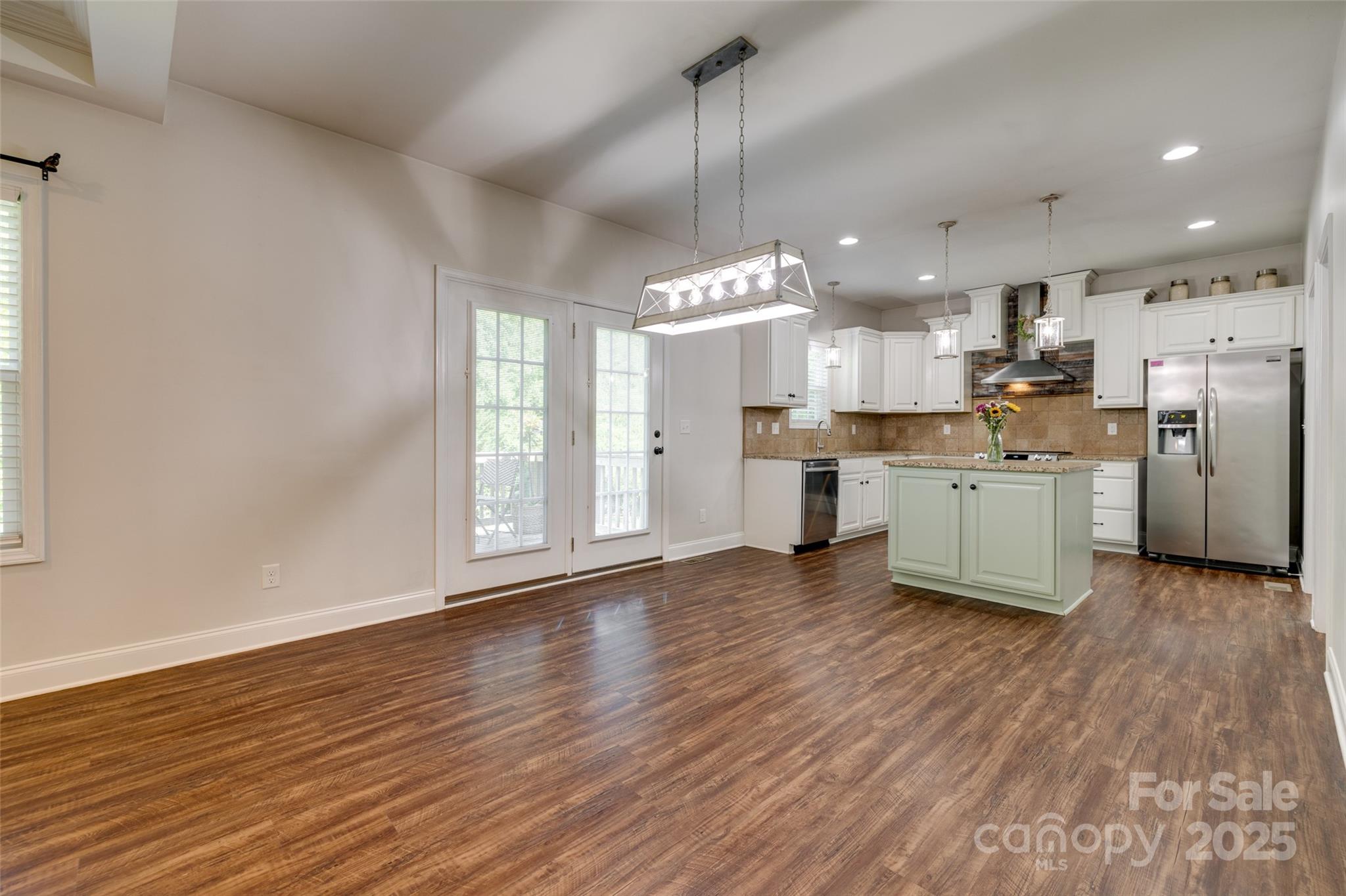 3243 Farmcrest Court Fort Mill, SC 29708 - Photo 6 of 45 a view of a kitchen with stainless steel appliances granite countertop a stove a sink dishwasher a refrigerator white cabinets and wooden floor next to a window