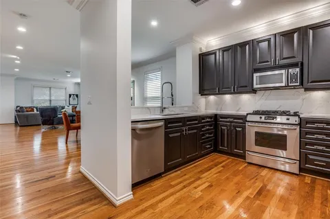 a kitchen with stainless steel appliances kitchen island granite countertop a stove and a sink