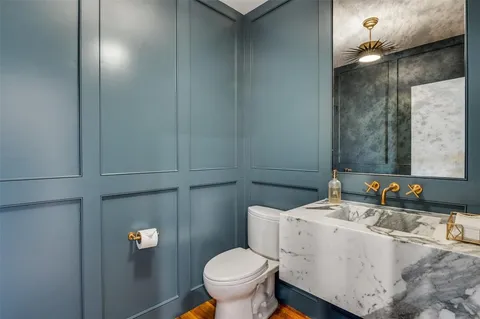 a bathroom with a granite countertop toilet and a sink