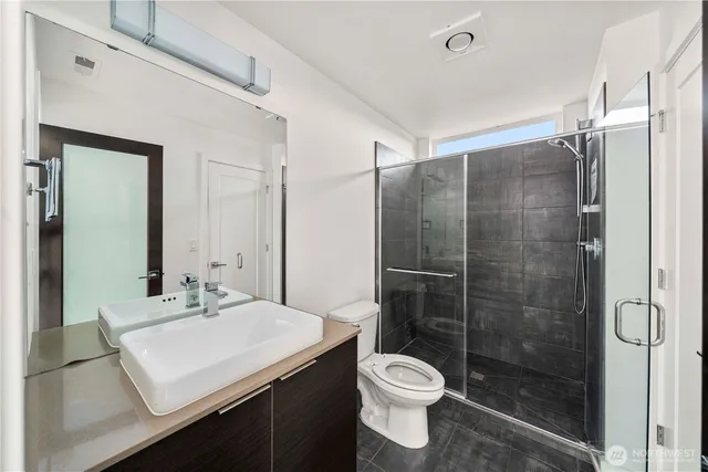 a bathroom with a sink toilet a mirror and shower