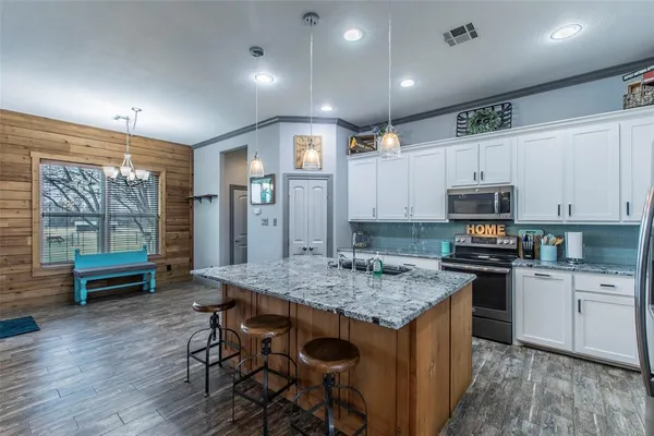 a kitchen with stainless steel appliances granite countertop a stove refrigerator and cabinets
