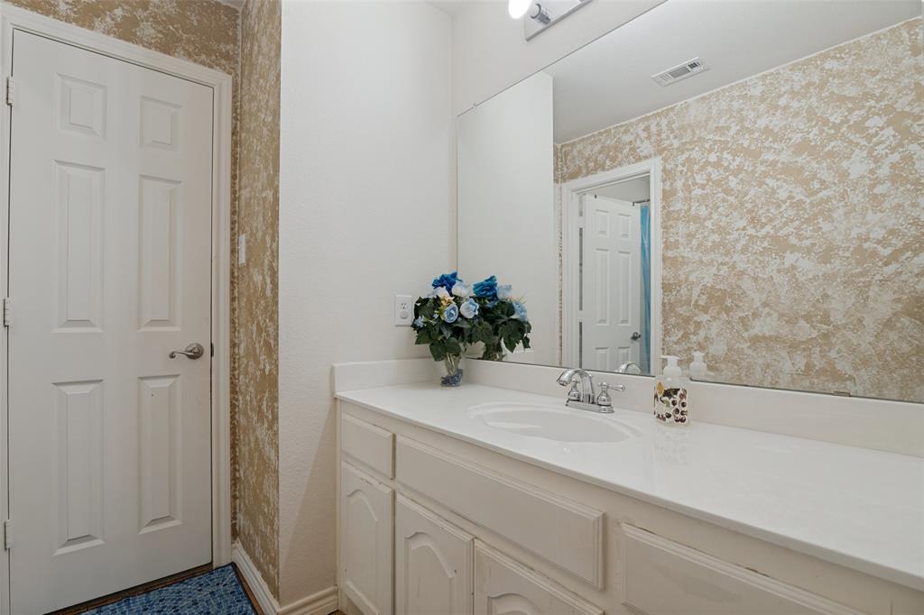 2213 Ranch Road Sachse, TX 75048 - Photo 25 of 28 White paneled door, built-in vanity with white cabinetry, integrated sink, and a large wall-mounted mirror