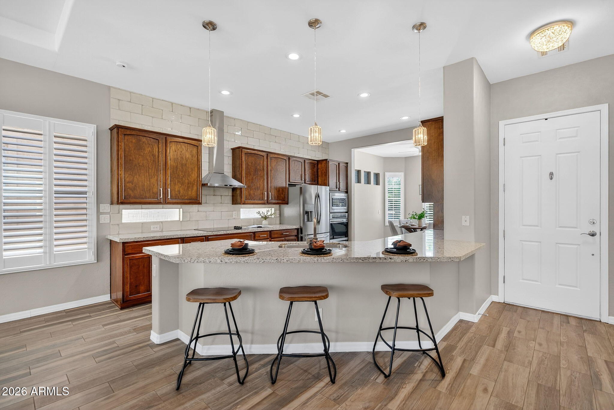4128 East Jude Lane Gilbert, AZ 85298 - Photo 10 of 58 a kitchen with stainless steel appliances a dining table chairs and wooden floor