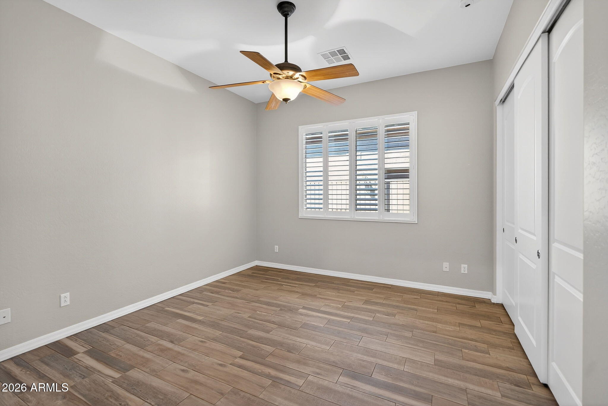 4128 East Jude Lane Gilbert, AZ 85298 - Photo 34 of 58 a view of a room with wooden floor a ceiling fan and windows