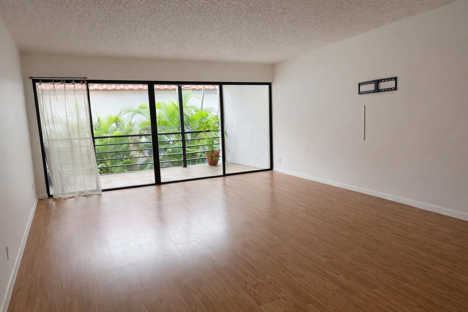 2001 Woolbright Road, Unit F204 Boynton Beach, FL 33426 - Photo 3 of 7 an empty room with wooden floor and windows