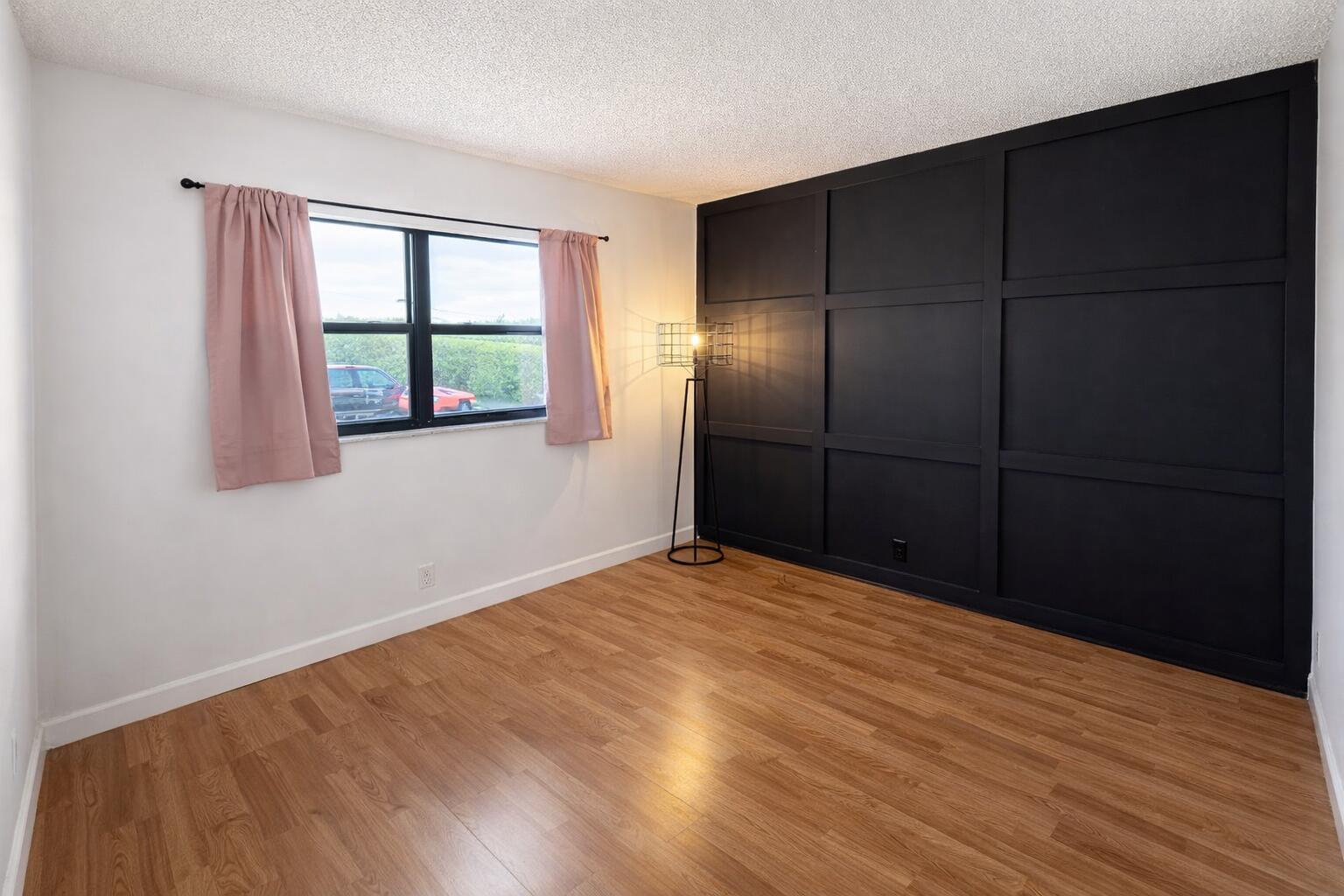 2001 Woolbright Road, Unit F204 Boynton Beach, FL 33426 - Photo 4 of 7 a view of an empty room with wooden floor and a window