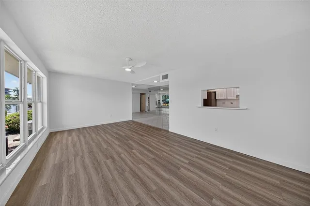 an empty room with wooden floor and a window