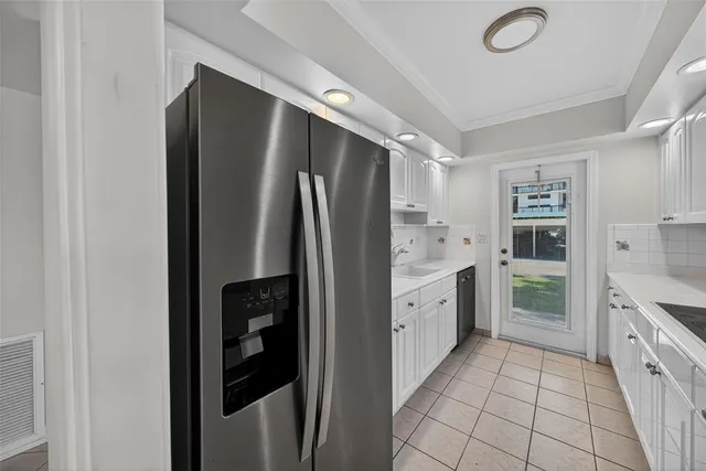 a kitchen with granite countertop a sink and refrigerator