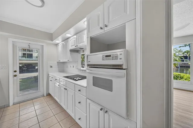 a kitchen with kitchen island white cabinets a refrigerator and a sink