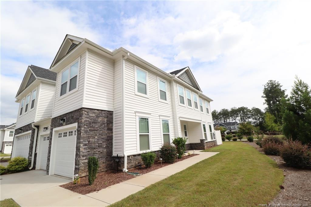 a view of a house with a yard and sitting area