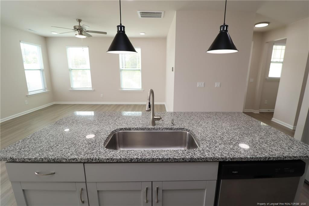 104 Kineton Woods Way Garner, NC 27529 - Photo 13 of 43 a kitchen with kitchen island granite countertop a sink a counter top space and cabinets