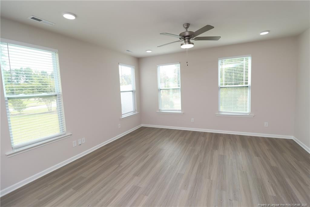 104 Kineton Woods Way Garner, NC 27529 - Photo 14 of 43 a view of an empty room with wooden floor and a window