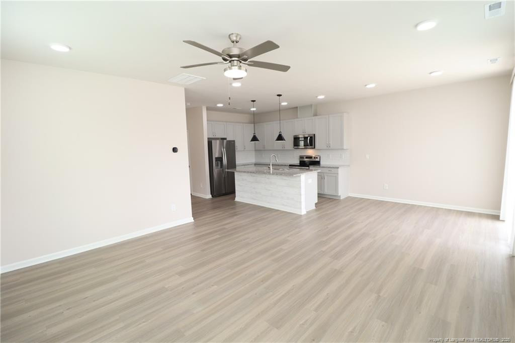 104 Kineton Woods Way Garner, NC 27529 - Photo 16 of 43 a view of a kitchen with a sink a refrigerator and wooden floor