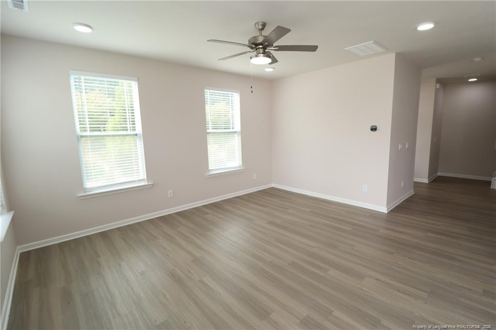 104 Kineton Woods Way Garner, NC 27529 - Photo 17 of 43 a view of an empty room with wooden floor and a window