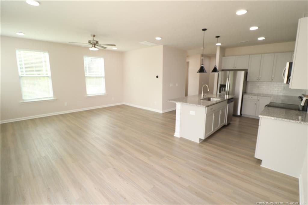 104 Kineton Woods Way Garner, NC 27529 - Photo 19 of 43 a kitchen with kitchen island white cabinets and stainless steel appliances