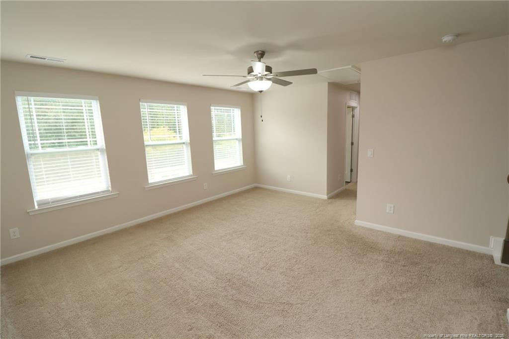 104 Kineton Woods Way Garner, NC 27529 - Photo 23 of 43 an empty room with chandelier fan and windows