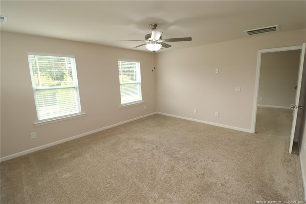 104 Kineton Woods Way Garner, NC 27529 - Photo 26 of 43 an empty room with windows and chandelier fan