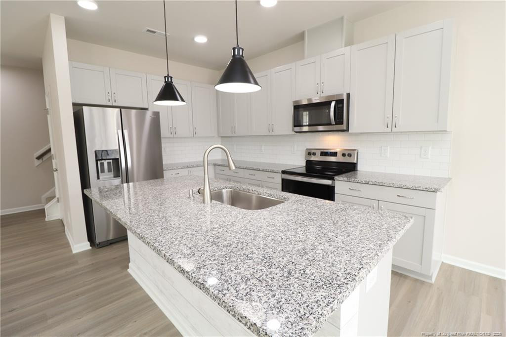 104 Kineton Woods Way Garner, NC 27529 - Photo 6 of 43 a kitchen with stainless steel appliances granite countertop a sink a stove and a refrigerator