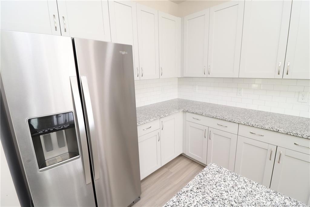 104 Kineton Woods Way Garner, NC 27529 - Photo 10 of 43 a kitchen with stainless steel appliances white cabinets and a refrigerator