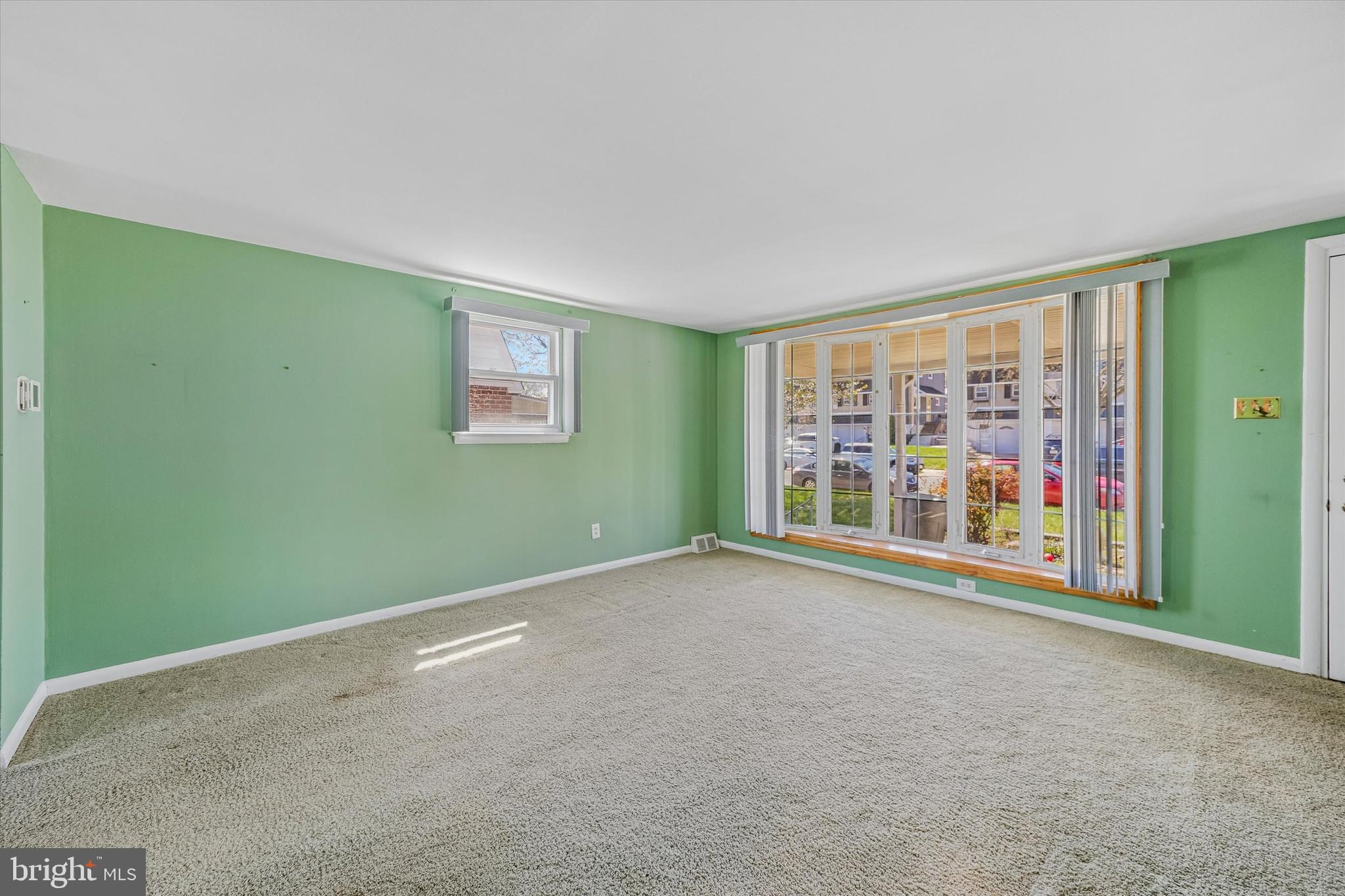 3527 Primrose Road Philadelphia, PA 19114 - Photo 7 of 25 an empty room with a fireplace and a large window
