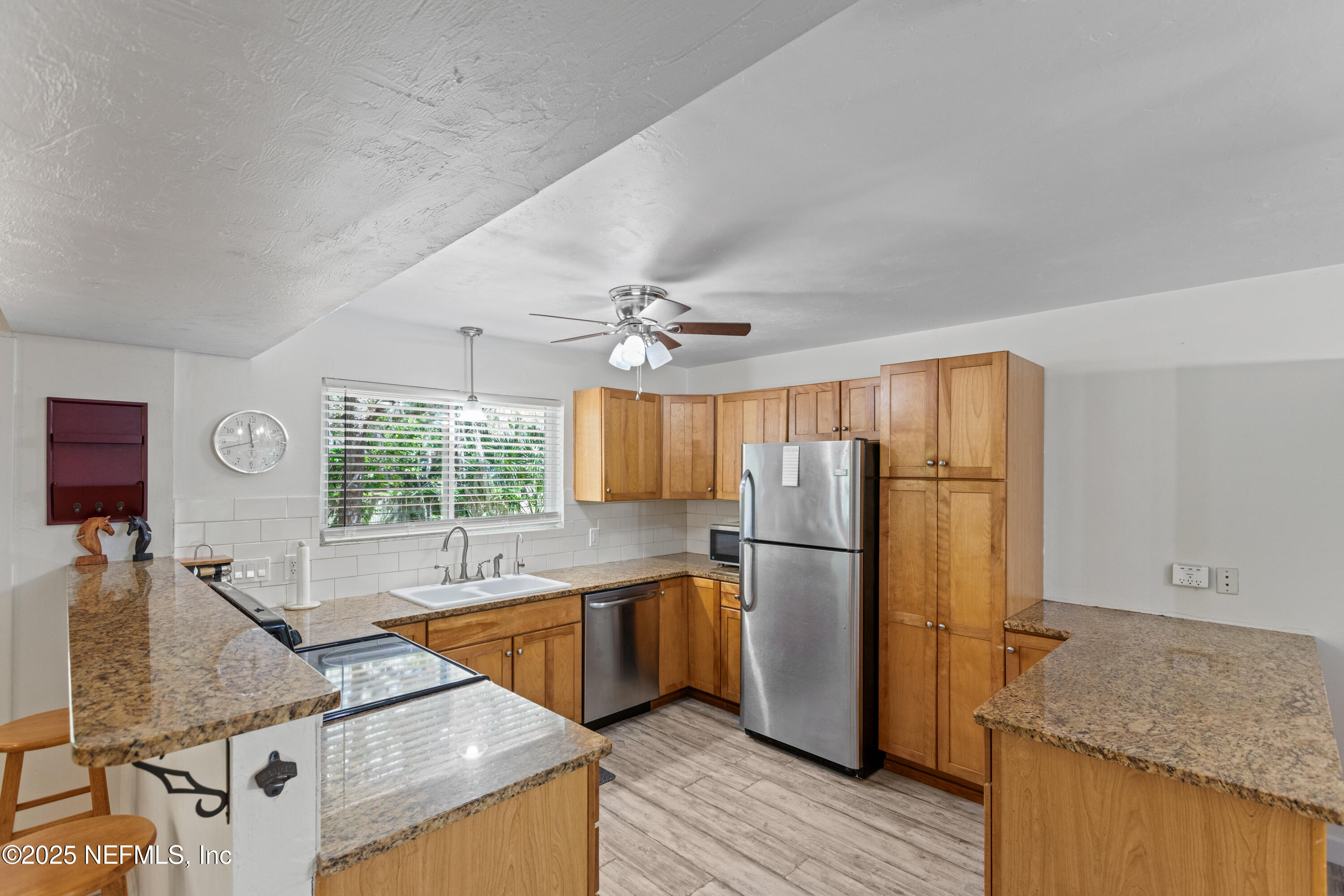 303 Southeast 3rd Avenue Melrose, FL 32666 - Photo 11 of 90 a kitchen with stainless steel appliances granite countertop a refrigerator a oven a sink with island and chairs