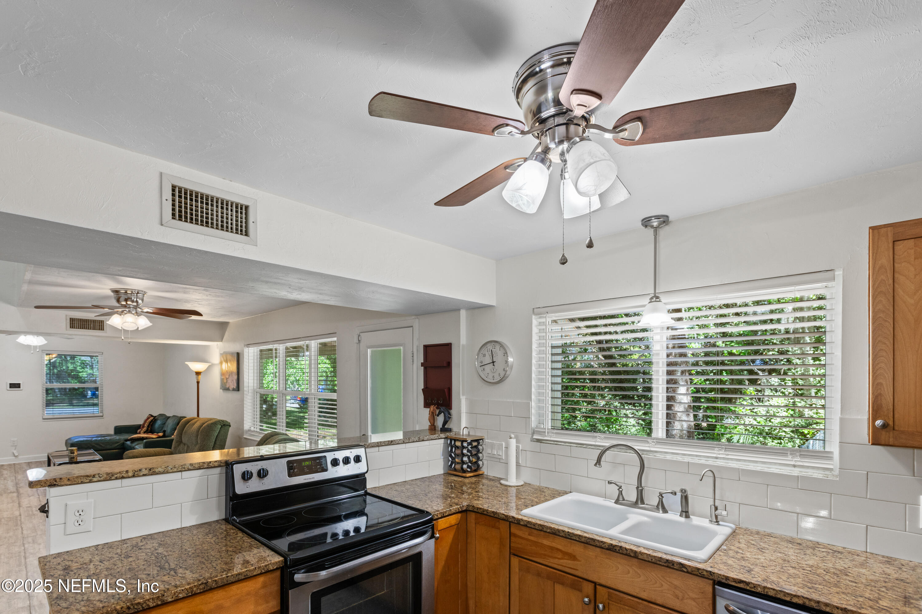 303 Southeast 3rd Avenue Melrose, FL 32666 - Photo 13 of 90 a kitchen with a stove a sink a window and stainless steel appliances