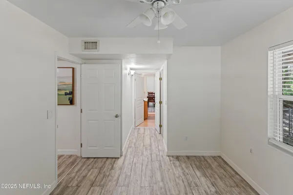 a view of a livingroom with wooden floor and a ceiling fan