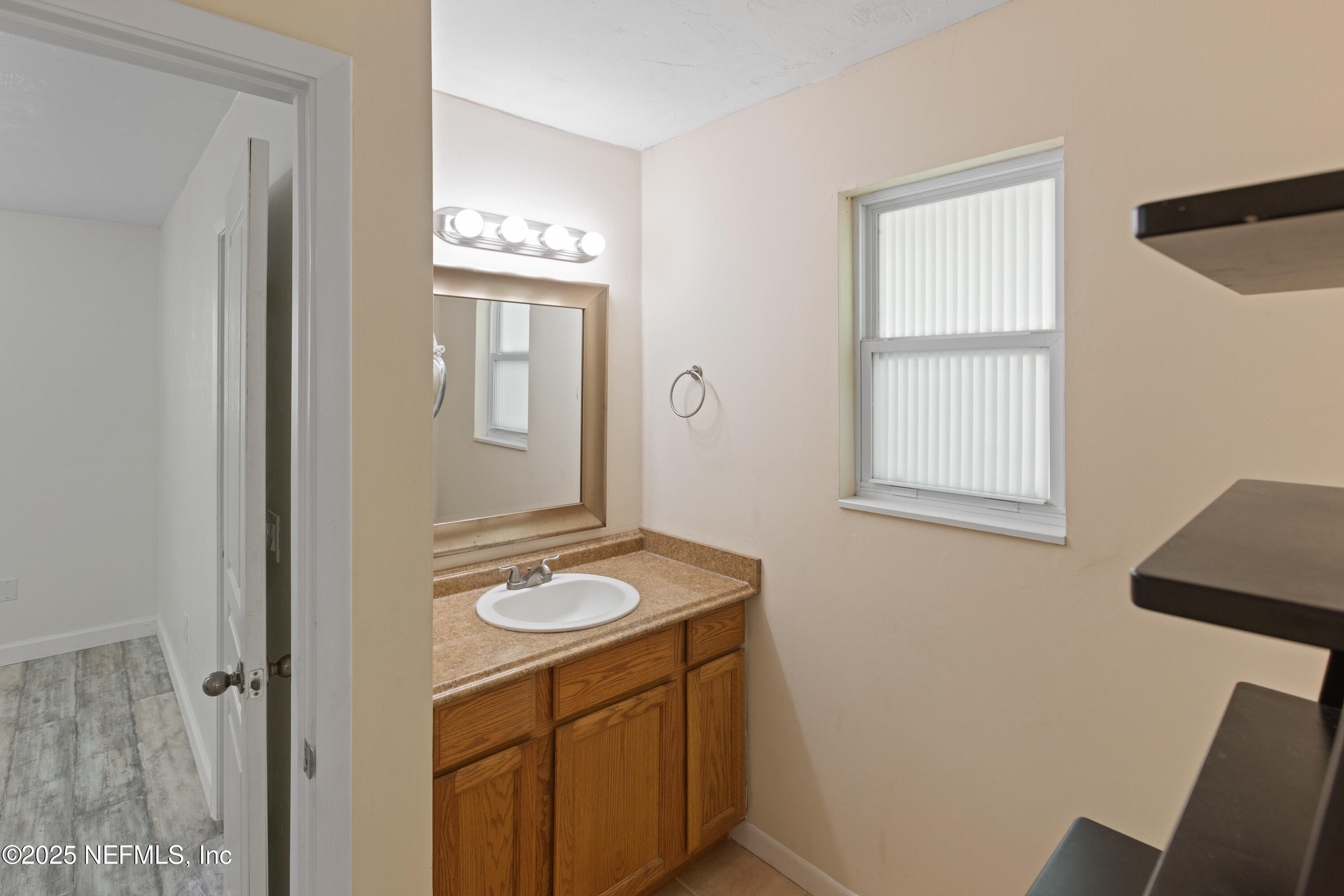 303 Southeast 3rd Avenue Melrose, FL 32666 - Photo 37 of 90 a bathroom with a granite countertop sink and a mirror