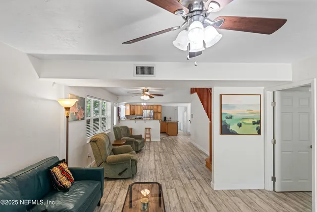 a living room with furniture floor to ceiling window and a flat screen tv