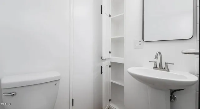 a bathroom with a sink a toilet and mirror
