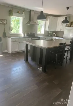 a kitchen with kitchen island granite countertop a sink window and cabinets