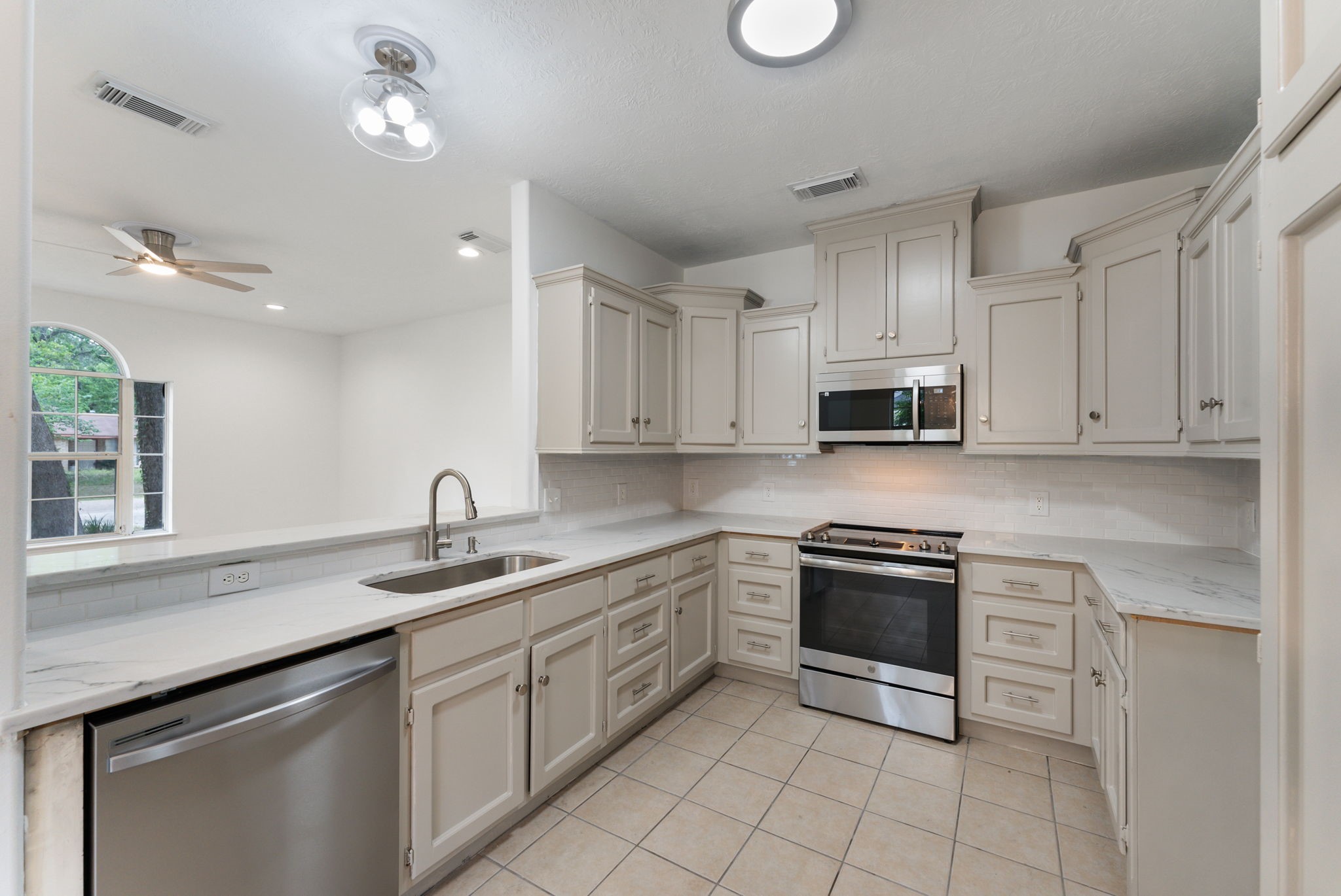 92 Tupelo Lane Conroe, TX 77304 - Photo 11 of 21 a kitchen with granite countertop a sink stainless steel appliances and white cabinets