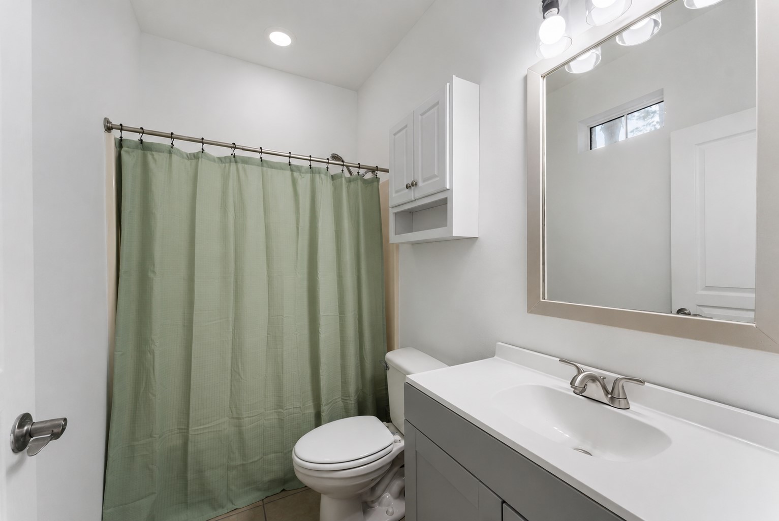 92 Tupelo Lane Conroe, TX 77304 - Photo 16 of 21 a bathroom with a sink a toilet a mirror and shower curtain