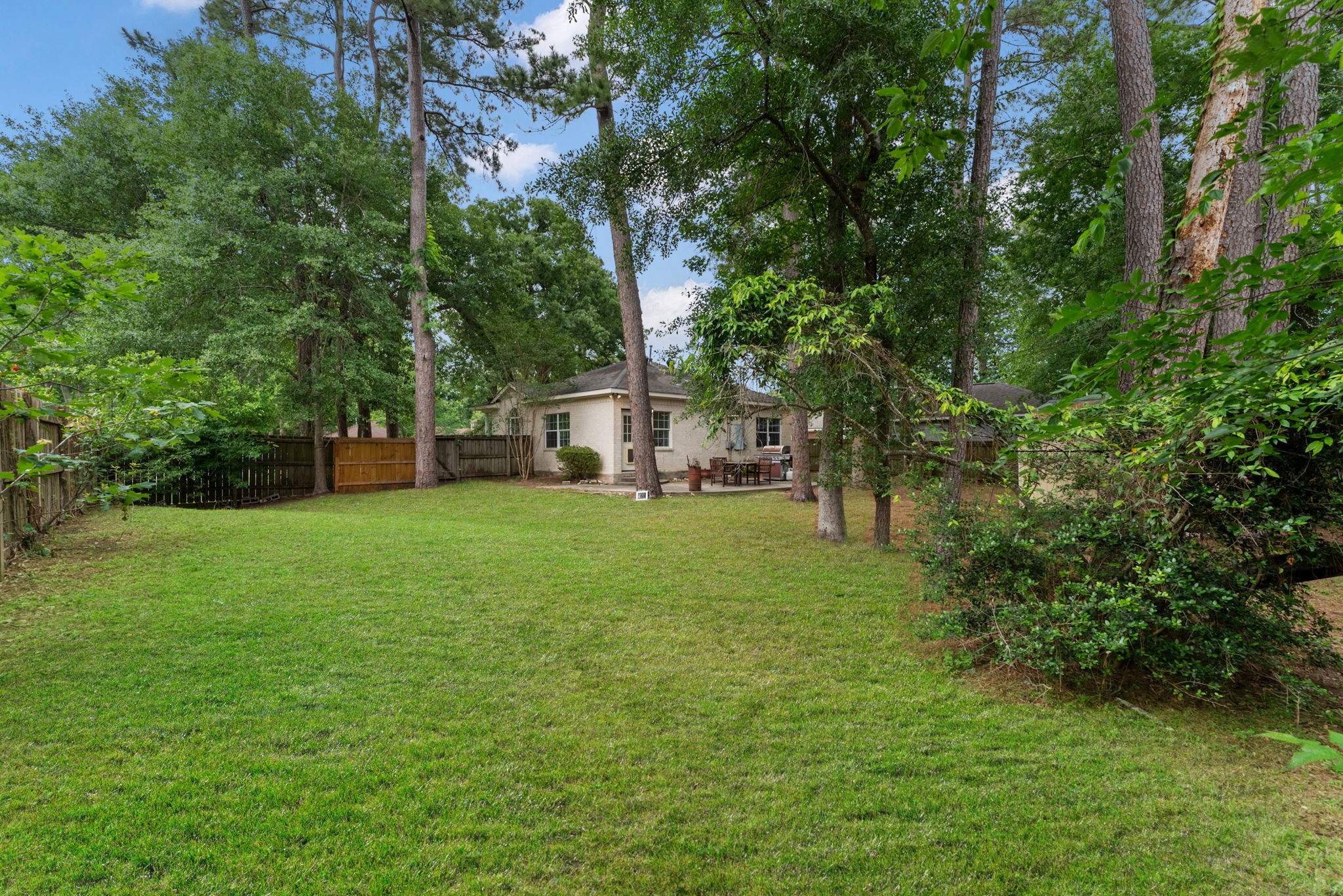 92 Tupelo Lane Conroe, TX 77304 - Photo 21 of 21 a view of a white house in front of a big yard with plants and large trees