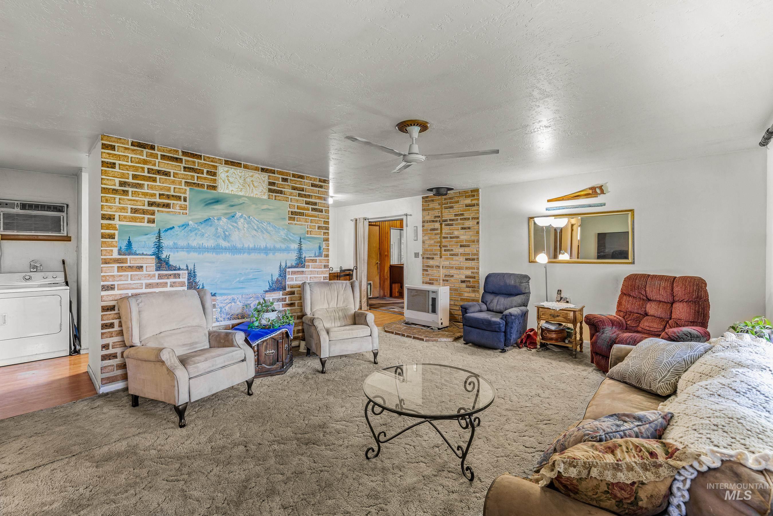 7026 S Highway Riggins, ID 83549 - Photo 19 of 50 Exposed brick accent wall, ceiling fan, and wall-mounted air conditioning unit