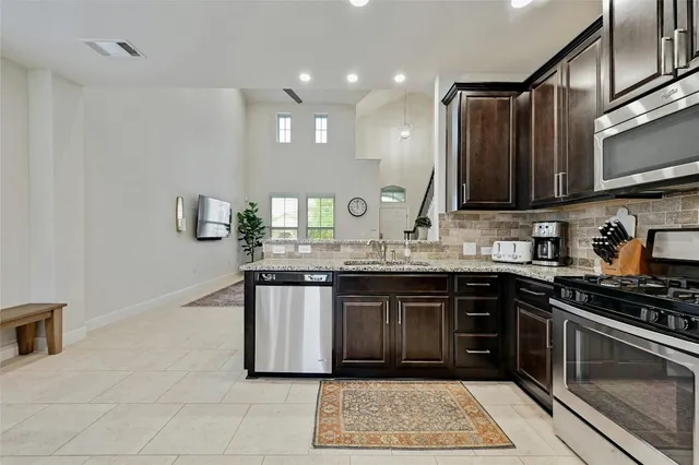 a kitchen with stainless steel appliances granite countertop a sink stove and cabinets