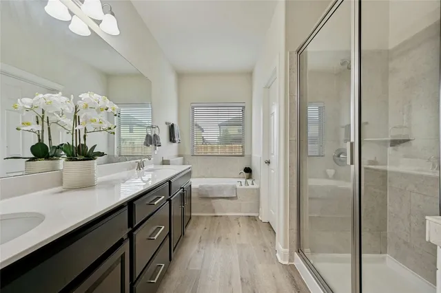 a spacious bathroom with a granite countertop sink a mirror and a shower