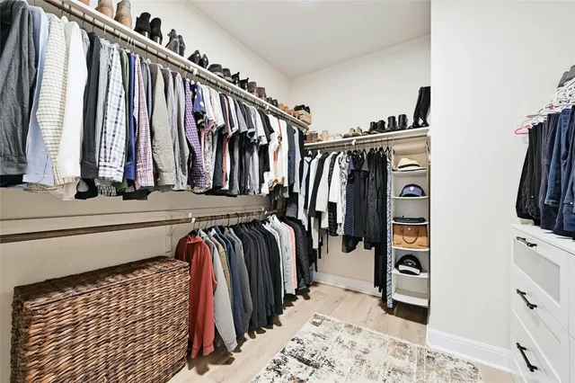 a view of walk in closet with clothes and shoes