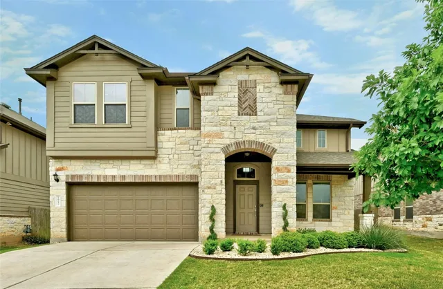 a front view of a house with a yard and garage